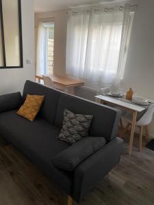 uma sala de estar com um sofá e uma mesa em Studio neuf avec jardin privatif em Bouguenais