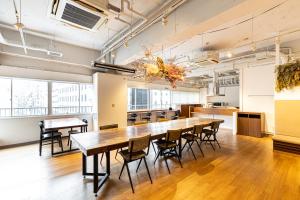 a large dining room with a long table and chairs at Hostel OGK in Osaka