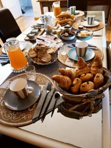 La Douce Parenthèse - 3 chambres d'hôtes-Accueil motards في Montirat: طاولة إفطار مع المعجنات والقهوة والبرتقال العصير