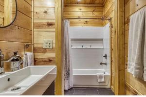 a bathroom with a sink and a bath tub at Hawk’s View Log Cabin -Mountains in Gatlinburg. in Gatlinburg