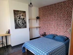 a bedroom with a bed and a brick wall at Le Presbytère de la côte d'opale in Nempont-Saint-Firmin