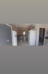 um quarto com frigoríficos e uma cozinha com uma mesa em Casa parque do Jacuípe em Camaçari