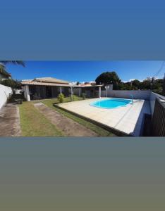 uma casa com uma piscina e uma cerca em Casa parque do Jacuípe em Camaçari