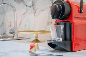 a red blender sitting on a counter with a glass at Résidence Le Belleville in Paris +134 photos