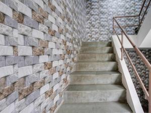 a brick wall with stairs in a room at OYO Hotel Moon in Rajkot