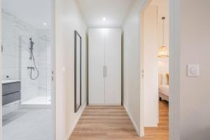 a white bathroom with a shower and a walk in shower at Résidence Le Belleville in Paris