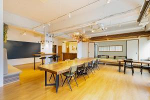 an empty classroom with a long table and chairs at Hostel OGK in Osaka