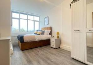 a bedroom with a bed and a large window at Flitwick Luxury Apartment in Flitwick