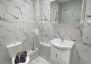 a white bathroom with a sink and a toilet at Flitwick Luxury Apartment in Flitwick