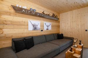 a living room with a couch and a wooden wall at Haus Valtellina in Sankt Gallenkirch +102 photos