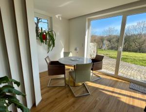a dining room with a table and chairs and a window at SONNENWEG Designwohnung mit Gartenblick in Plauen