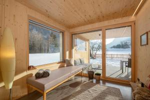 ein Wohnzimmer mit einem Sofa und einem großen Fenster in der Unterkunft Haus Valtellina in Galgenul