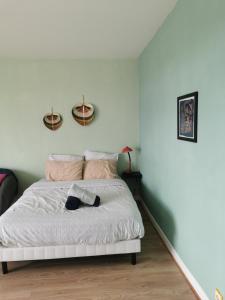 een slaapkamer met een wit bed en 2 manden aan de muur bij Appartement, charmant type F1 37m2 vue dégagée, in Commentry