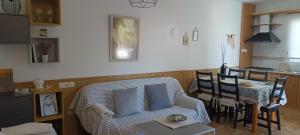 a living room with a couch and a table and a kitchen at Apto Blanes - WIFI GRATIS in San José