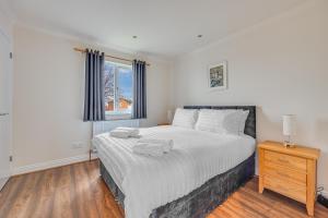 Un dormitorio con una cama grande y una ventana en Immaculate Two Bedroom House with Parking en Bedford