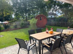 een tafel en stoelen op een patio met een tuin bij Ferienhaus Deine Zeit mit SAUNA und WALLBOX in Nettersheim