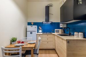 a kitchen with a wooden table and blue tiles at Certosa Charme 10 Minuti da SAN SIRO e RHO FIERA in Milan