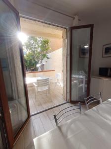 ラ・マッダレーナにあるAppartamento Vacanze alla Maddalenaのベッドルーム1室(ガラスのスライドドア付)、パティオが備わります。