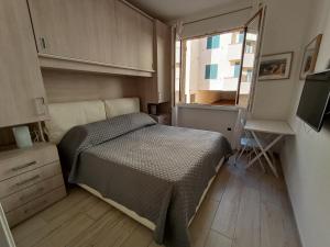 ラ・マッダレーナにあるAppartamento Vacanze alla Maddalenaの小さなベッドルーム(ベッド1台、窓付)