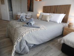 トレモリノスにあるLa Torre de la Colina Playaのベッドルーム1室(大型ベッド1台、タオル付)