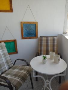 une table et deux chaises ainsi qu'une table et des chaises blanches dans l'établissement My Sisters House, à Agios Nikolaos