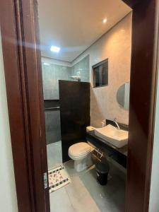 a bathroom with a toilet and a sink at Vila flores e mar in São Miguel do Gostoso