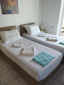 two beds in a room with towels on them at My Sisters House in Agios Nikolaos