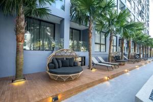 a room with palm trees and a couch in a building at Deluxe apartment Citygate Condo by Lofty in Kamala Beach