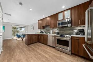 uma cozinha com utensílios de aço inoxidável e armários de madeira em Gem 2-Story Retreat Private Rooftop Terrace, Pool. em Los Angeles