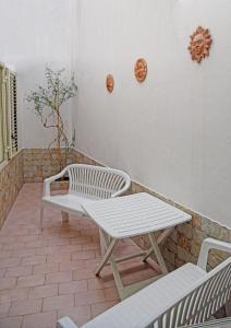 una panchina bianca e un tavolo su un patio di Casa Celeste 2 a Noto