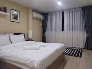 - une chambre avec un grand lit blanc et une fenêtre dans l'établissement RB6: StreetFood jay-o Samyan/chinaTown/mrt, à Bangkok