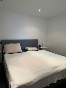 ein weißes Bett mit zwei Kissen darüber in der Unterkunft Appartamento fronte lago in Muralto