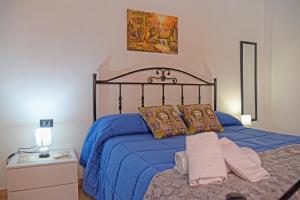 Schlafzimmer mit einem Bett mit blauer Tagesdecke in der Unterkunft Casa Celeste in Noto