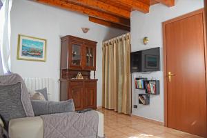 ein Wohnzimmer mit einem Sofa und einem TV in der Unterkunft Casa Celeste in Noto