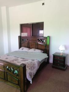 a bedroom with a large wooden bed and a table at Red rose apartment in Jerash