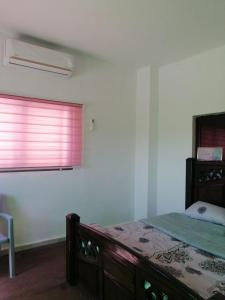 a bedroom with a bed and a window at Red rose apartment in Jerash