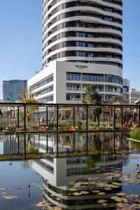 a building with a reflection in a body of water at The George Tel Aviv in Tel Aviv