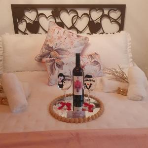 a bottle of wine and two glasses on a bed at La Gallania de Papá Pepe in Santa Lucía