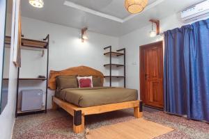 a bedroom with a bed with a wooden headboard at Bonsai Boutique Homes in Ibadan