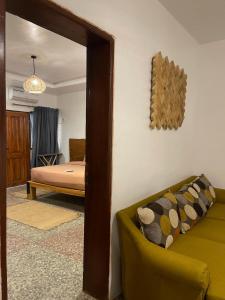 1 dormitorio con cama, sofá y espejo en Bonsai Boutique Homes en Ibadán