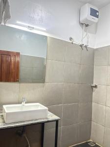 Bonsai Boutique Homes في إيبادان: حمام مع حوض ومرآة