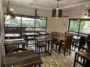 a restaurant with wooden tables and chairs in a room at Bonsai Boutique Homes in Ibadan
