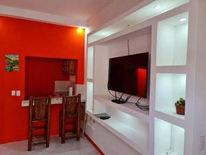 een woonkamer met een tv en een rode muur bij Casa Naranja in Granada