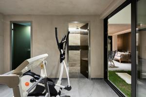 a room with a gym with a treadmill and a bedroom at The Sand Villas - 5star Living on the Beach in Agios Nikolaos