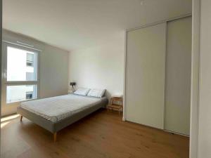 ein Schlafzimmer mit einem Bett und einer großen Schiebetür in der Unterkunft Charmant appartement à 20 min de Paris centre in Bagneux
