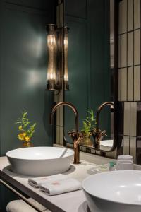 a bathroom with a sink and a large mirror at The George Tel Aviv in Tel Aviv