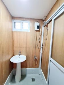 La salle de bains est pourvue d'un lavabo et d'une douche. dans l'établissement Dasma Lofts Hotel near Dela Salle Dasma, à Dasmariñas