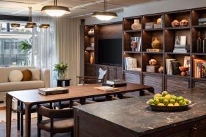 a living room with two tables and a tv at The George Tel Aviv in Tel Aviv