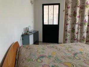 a bedroom with a bed and a door with a window at T2 au calme montagne et lac in La Bâtie-Vieille