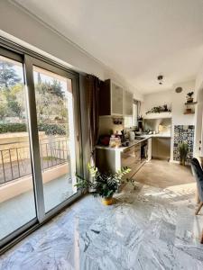 a kitchen with a large glass door and a kitchen with a kitchen at Beau 2 pièces,Terrasse, Parking Menton Centre in Menton